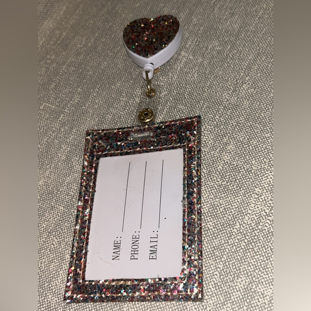 Glittery multi coloured badge holder with heart shaped retractable clip